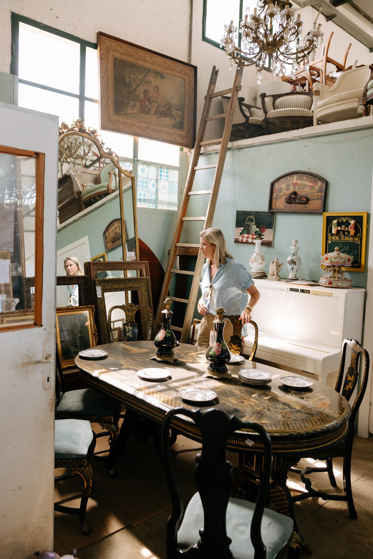 Antique furniture and framed prints inside Il Vecchiuccio in Pietrasanta.