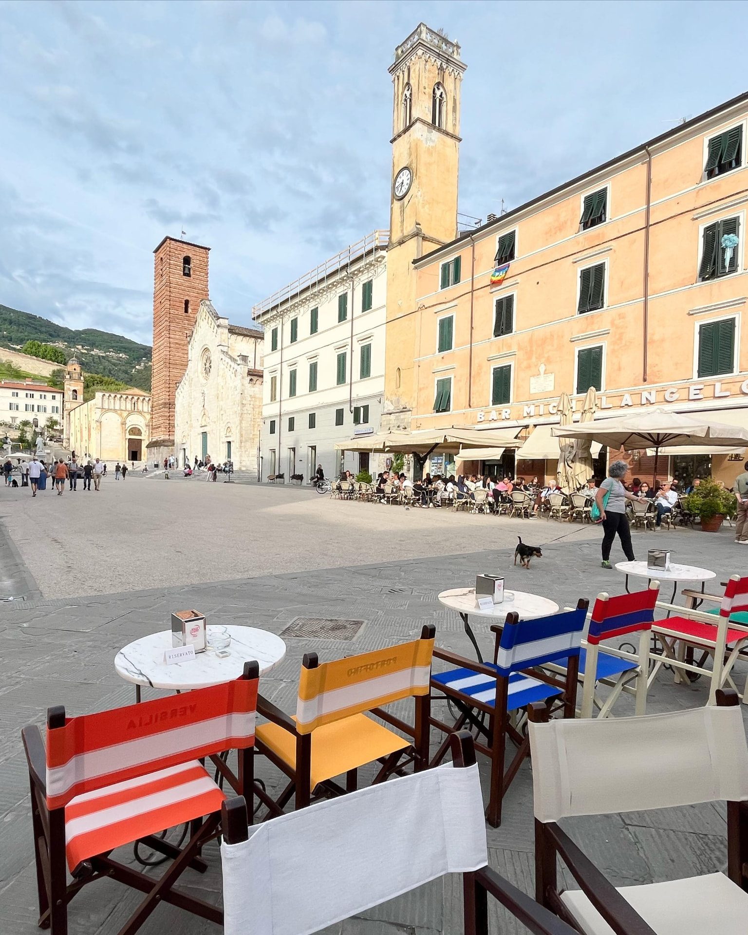 Coloured deck chairs and marble tables facing Piazza Duomo in Pietrasanta.