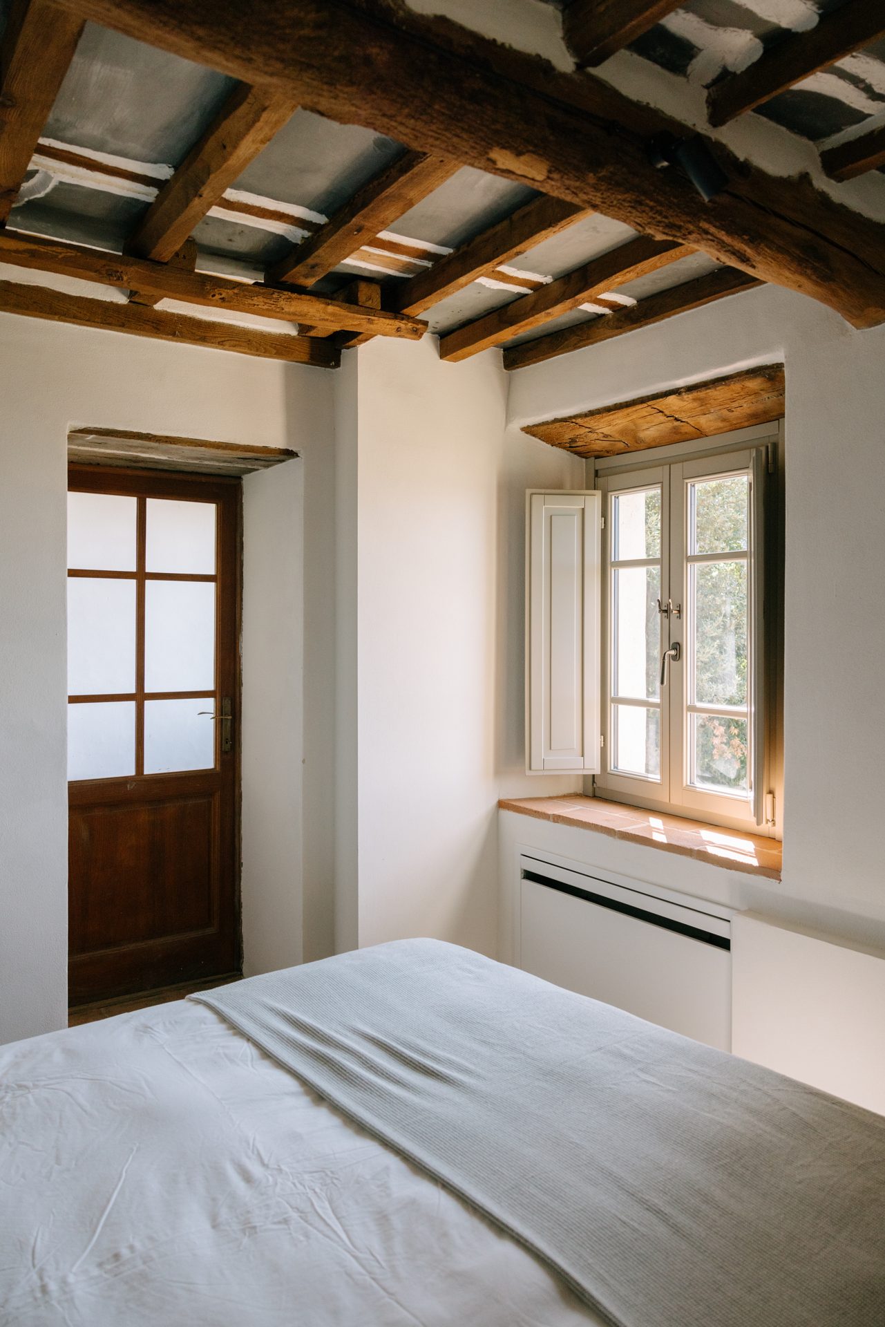 A bedroom prepared beneath the old beams
