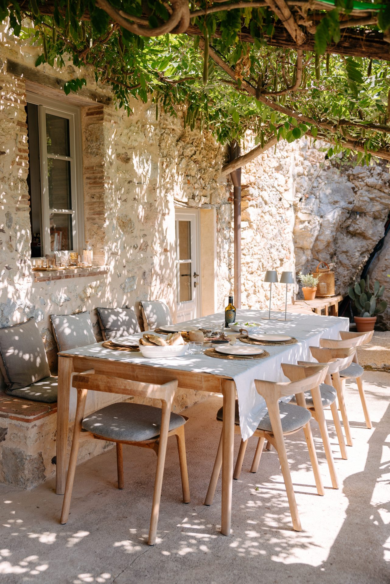 The long dining table beneath the wisteria-covered veranda